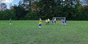 after school club group on a field playing football